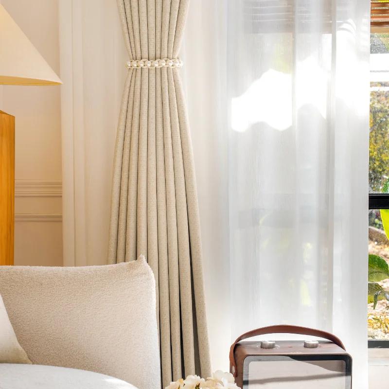 Beige high-density curtain in soft daylight, paired with sofa and sheer panel for a serene home setting