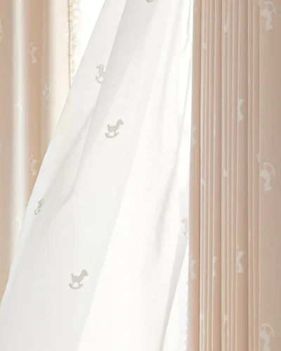 Soft light filtering through sheer curtain layered over rocking horse jacquard kids curtain in pastel pink