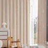 Rocking horse jacquard curtain in pastel pink softly filtering light in a kids’ room with wooden toys