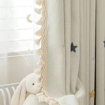 Starry Weave Curtain in nursery setting with embroidered stars and soft pompom trim