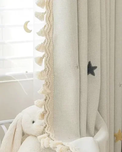 Starry Weave Curtain in nursery setting with embroidered stars and soft pompom trim