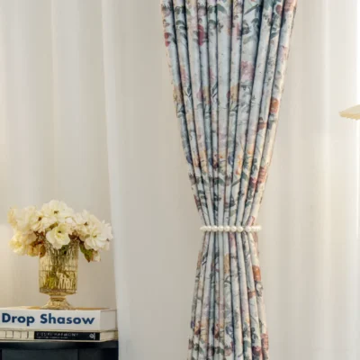 Front view of botanical print curtain tied back to show soft floral pattern and light-filtering effect.
