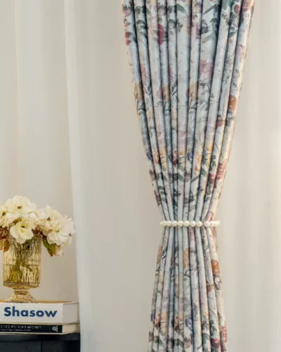 Front view of botanical print curtain tied back to show soft floral pattern and light-filtering effect.