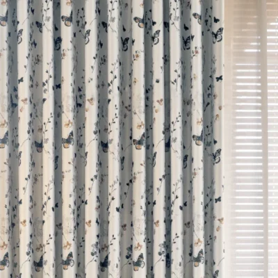 Front view of butterfly print curtains with soft floral design, showing full drape and pleat detail.