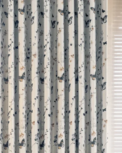 Front view of butterfly print curtains with soft floral design, showing full drape and pleat detail.