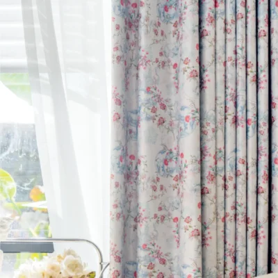 Bird and floral curtain in soft pastel tones, fully drawn beside a sheer panel