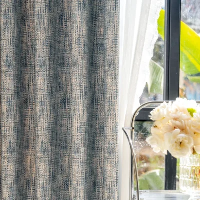 Close-up of Woven Print Curtain in deep indigo and beige, showcasing faux textured print beside a bright window with flowers