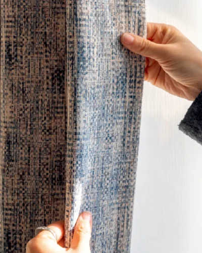 Hand touching Woven Print Curtain in indigo and beige, showing faux woven texture and soft drape