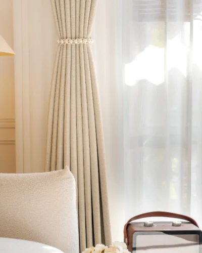 Sierra Weave Curtain hanging in a softly lit living room, showcasing high-density fabric with elegant woven texture and gentle daylight filtering.