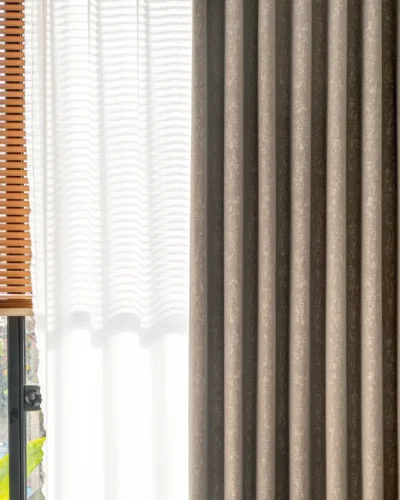 Gold-tone texture curtain in modern interior, softly filtering daylight through precision-woven fabric.