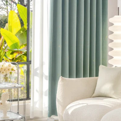 Living room with blue-grey dragonfly texture curtains and soft natural lighting.