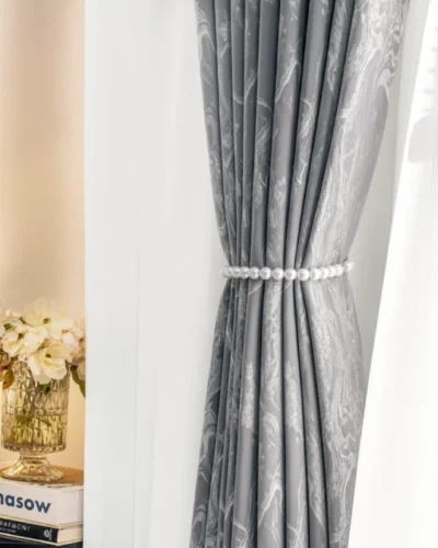 Grey stone vein jacquard curtain with tieback, layered with white sheer drape in natural light
