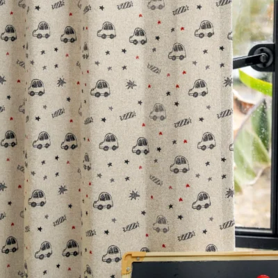 Cartoon car curtain with star print shown fully drawn in a kids room