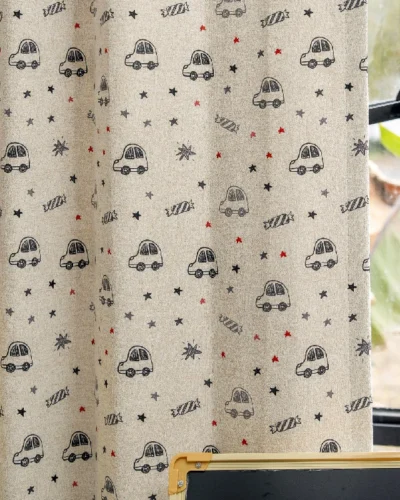 Cartoon car curtain with star print shown fully drawn in a kids room
