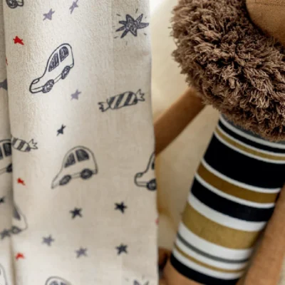 Close-up of cartoon car curtain fabric with candy and star prints in kids room