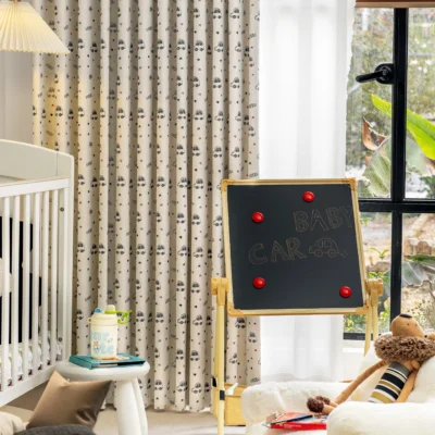 Cartoon car print curtain in nursery room with blackboard and baby crib