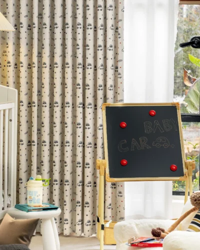 Cartoon car print curtain in nursery room with blackboard and baby crib