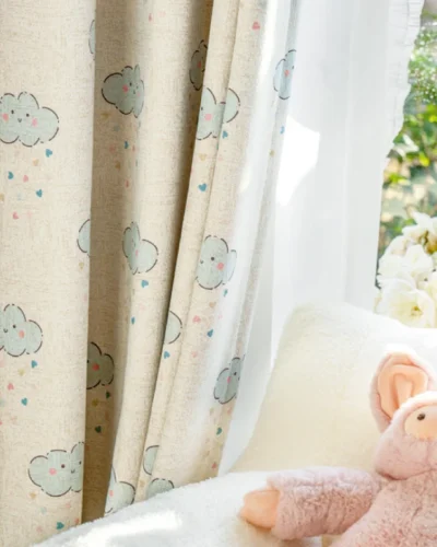 Close-up of smiling cloud curtain next to plush toy in a baby room