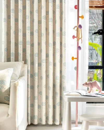Smiling cloud curtain with pastel raindrop print hanging in a bright children’s room