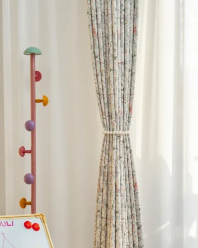 Fairy tale curtain tied back with soft pleats and pastel storybook print for kids