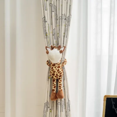 Giraffe print curtain tied with plush toy in softly lit children’s room