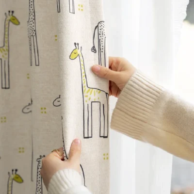 Hand touching giraffe print curtain in children's room with natural light