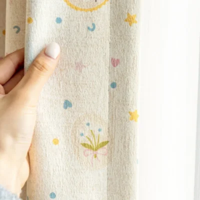 Close-up of Happy Day Curtain showing pastel birthday patterns and soft fabric texture