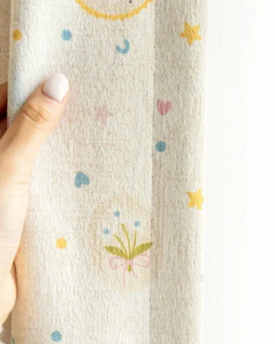 Close-up of Happy Day Curtain showing pastel birthday patterns and soft fabric texture