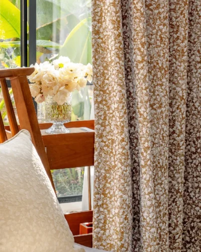 Brown printed curtain with dense floral patterns hanging by a wooden chair – Lemonhone