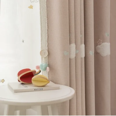 Close-up of kids curtain in pink with heart embroidery and soft light filtering fabric.
