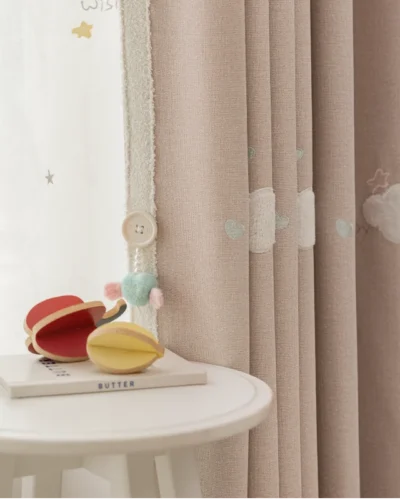 Close-up of kids curtain in pink with heart embroidery and soft light filtering fabric.