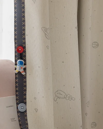 Close-up of fine embroidery on kids' space-themed curtain with stitched planet and star details