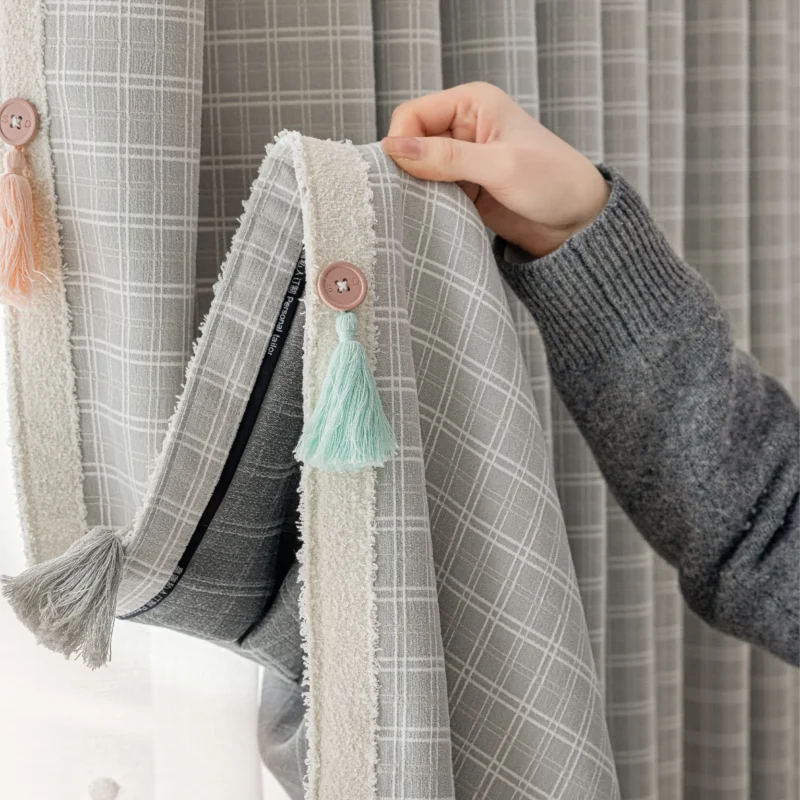 Close-up of Whisper Glow Curtain with soft British plaid jacquard texture and hand-holding detail