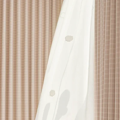 Sheer curtain layer with embroidered dots behind the Gridline Whisper Curtain – soft modern layering
