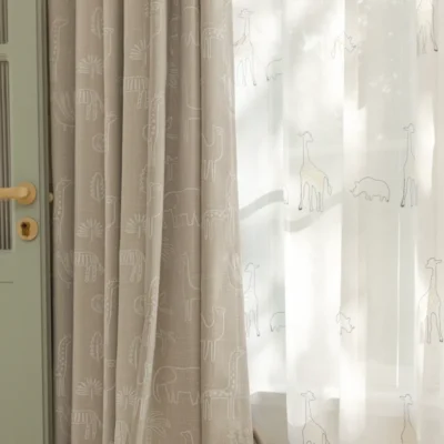 Forest dream curtain layered with sheer white curtain – green animal jacquard fabric softly filtering light in a kids’ room