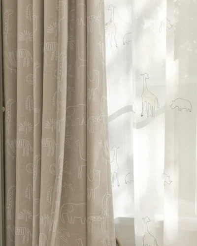 Forest dream curtain layered with sheer white curtain – green animal jacquard fabric softly filtering light in a kids’ room