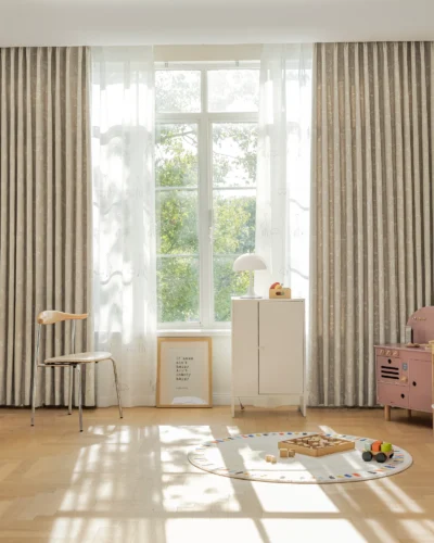 Full-room view of forest dream curtain in green animal jacquard fabric with giraffe pattern – softly filtering light in kids’ room