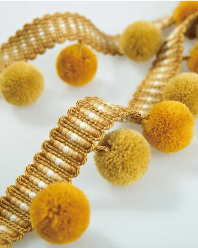 Golden yellow velvet pom pom fringe trim with warm tones and soft texture for curtain or upholstery.