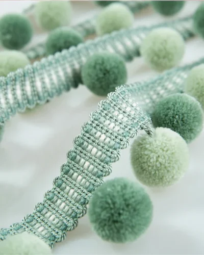 Soft sage green velvet pom pom fringe trim with textured ribbon for curtain or cushion edging.