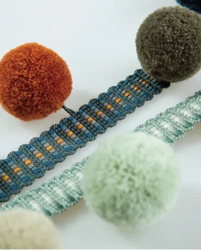 Colorful pom pom fringe with teal-orange trim and multicolor pom poms — adds playful contrast to modern interiors