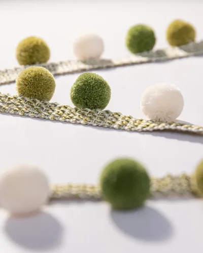Close-up of green and ivory pom pom tassel trim – Eden series
