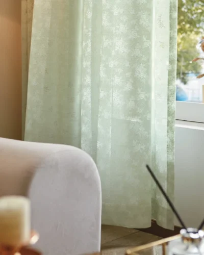 Olive Mist Curtain softly draping beside a sofa and window, filtering daylight in a cozy natural living space