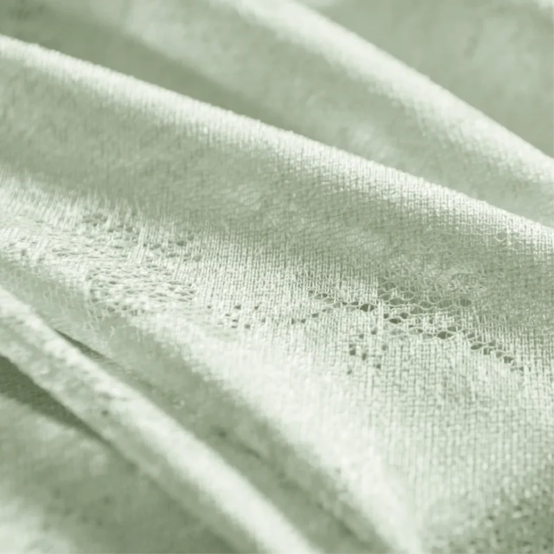 Close-up of Olive Mist Curtain fabric showing soft green botanical texture and airy voile weave