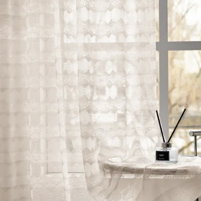 Elegant lace curtain filtering sunlight by the window in a cozy interior setting
