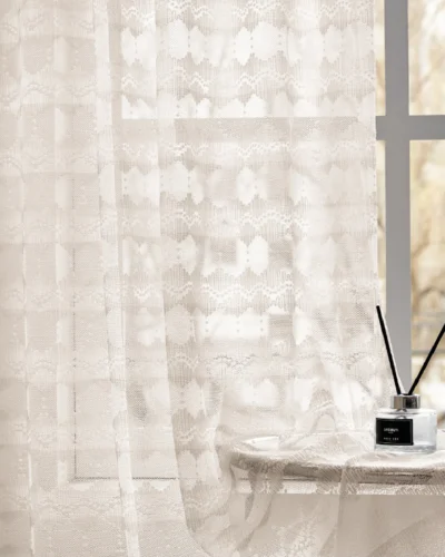 Elegant lace curtain filtering sunlight by the window in a cozy interior setting
