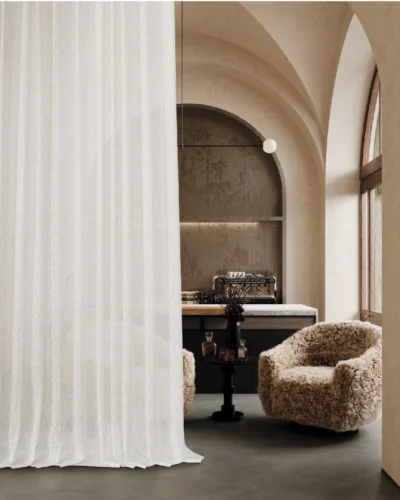 Lightflow lace curtain softly draping in an arched hallway with warm ambient light