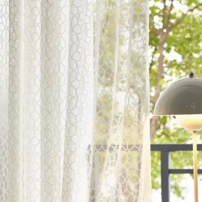 Lightflow lace curtain with elegant geometric patterns by a sunny window