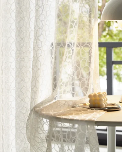 Lightflow lace curtain draped beside a sunny table setup in a serene room
