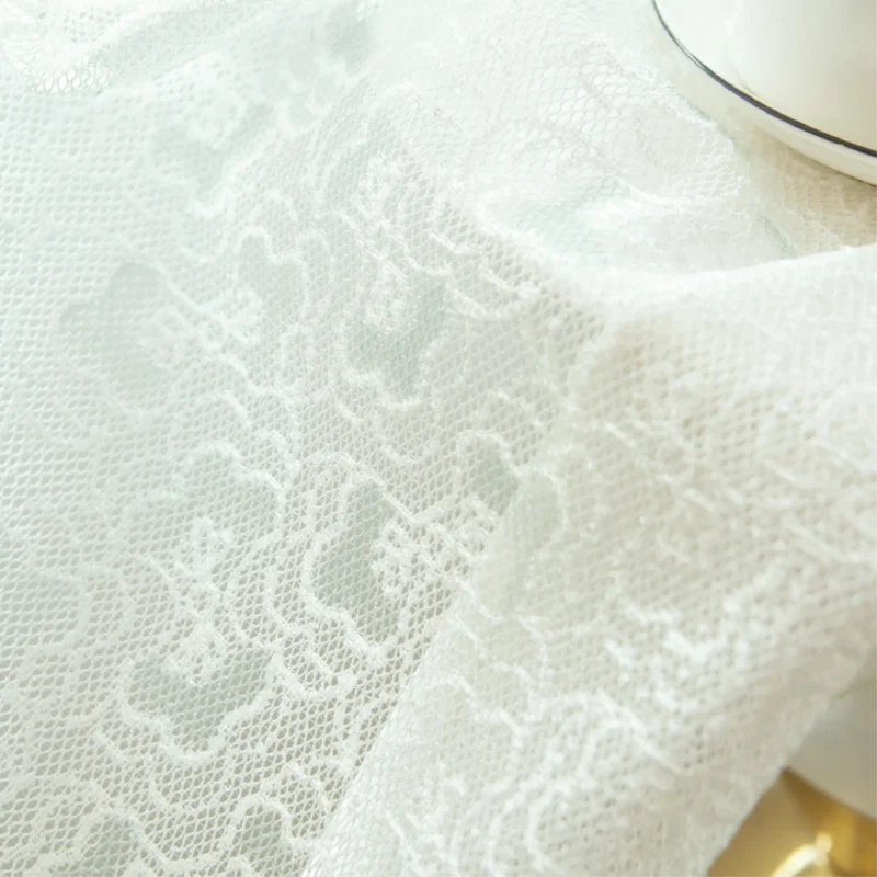 Close-up of Blossom Veil Sheer Curtain with floral lace texture beside a teacup