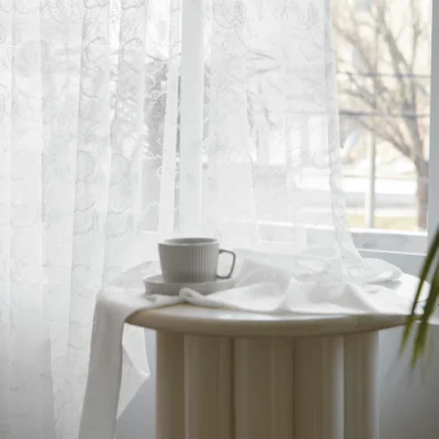 Leaf sheer curtain with morning light and tea cup on table